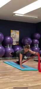 Pilates i Silkeborg - deltager på pilates matwork laver øvelser med elastik - flot udførsel i øvrigt
